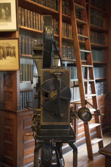 Photograph of the first movie camera created by Thomas Edison. The camera is made of metal, and is covered in dials, gears, a