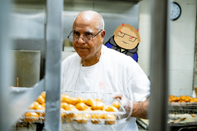 A photograph of a chef in a commercial kitchen carrying a tray of bread. A cartoon version of the blog author with devil horn